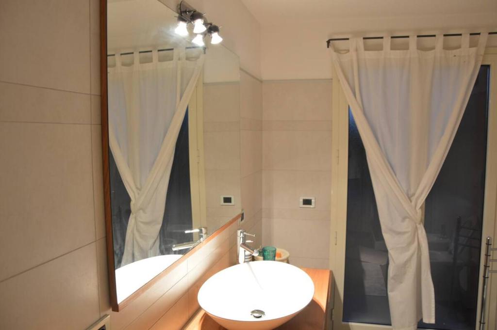 łazienka z umywalką i dużym lustrem w obiekcie Casa Vacanze Rocco w mieście Àrbatax