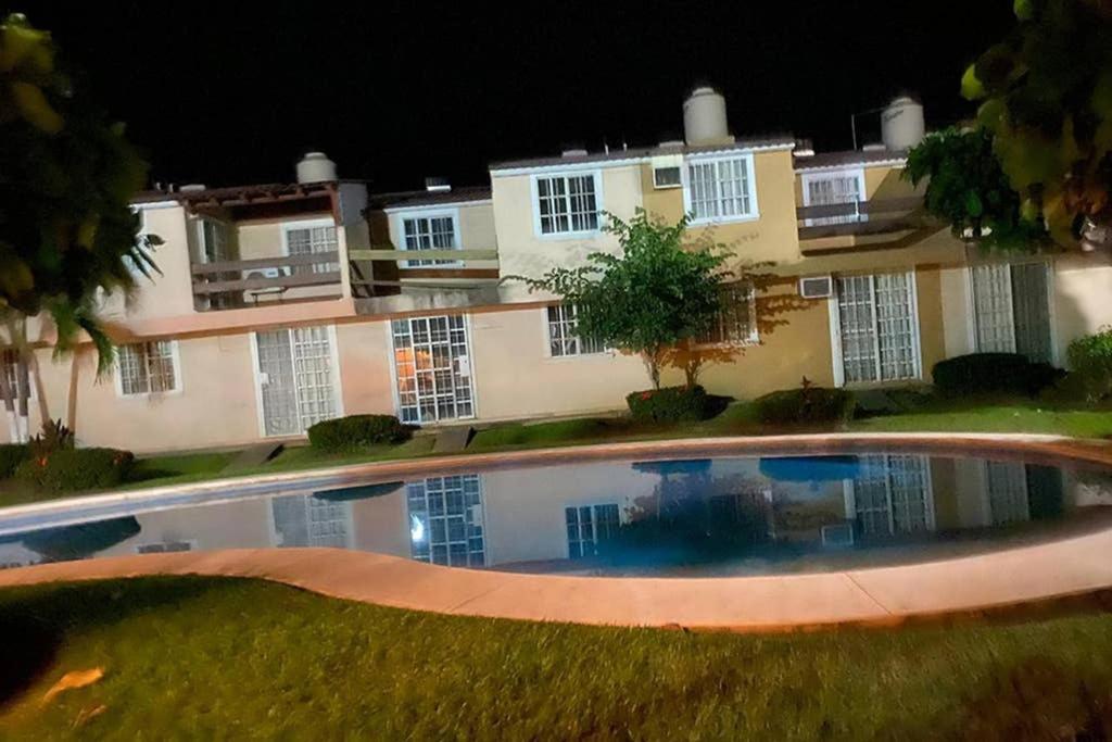伊斯塔帕的住宿－Joyas de Ixtapa... ¡El confort de tu Casa Ideal!，一座空的泳池,在晚上在建筑物前