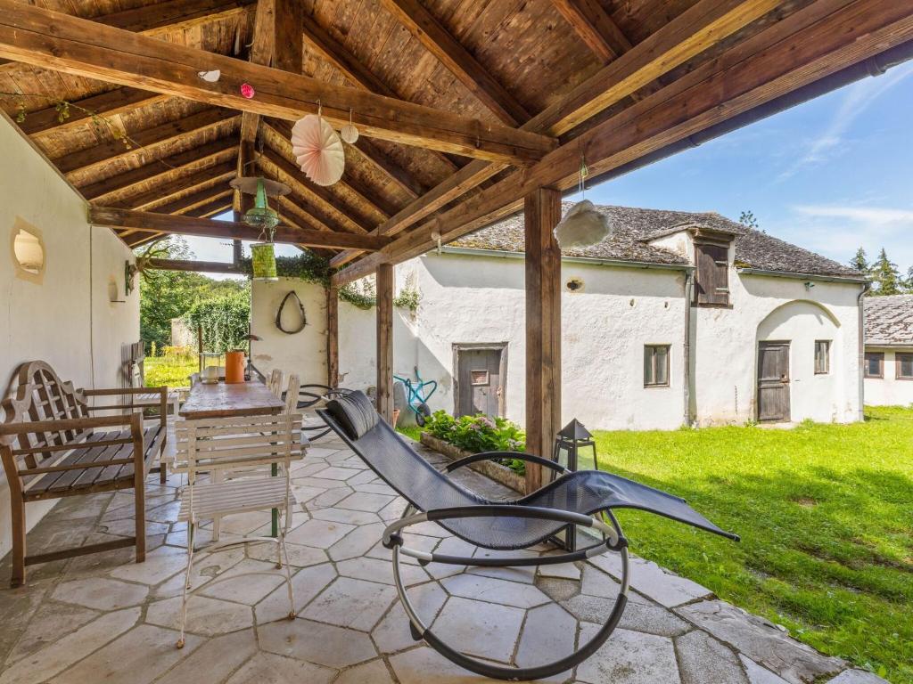 un patio con mesa y sillas bajo un techo de madera en Lavish Castle in Riedenburg with Garden near Lake en Riedenburg