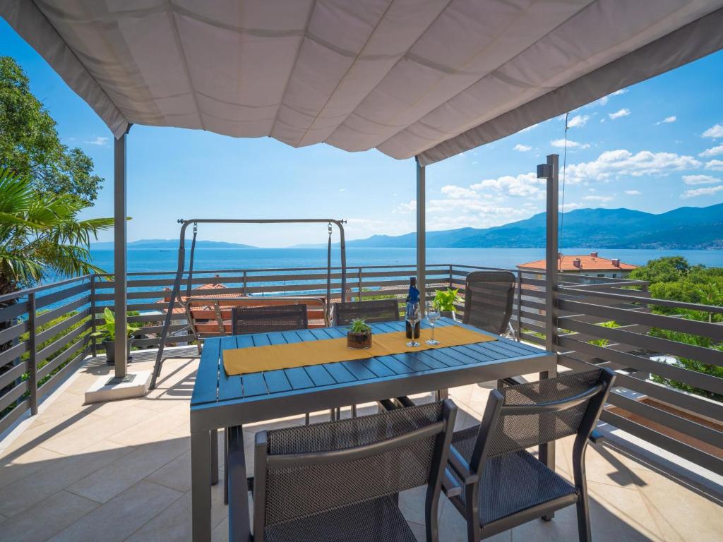 einen Tisch und Stühle auf einem Balkon mit Meerblick in der Unterkunft Holiday Home Matea by Interhome in Rijeka