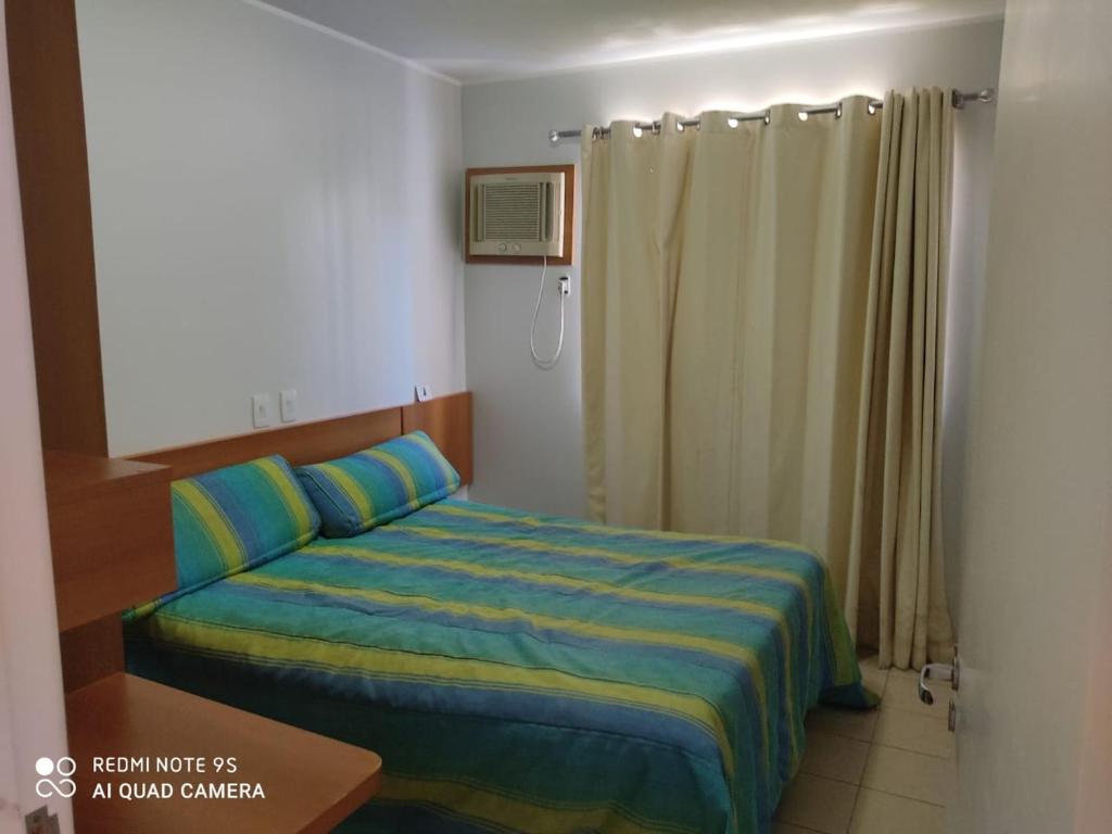 Schlafzimmer mit einem Bett mit blauer und gelber Bettwäsche in der Unterkunft Serra Park Flat 420 in Rio Quente