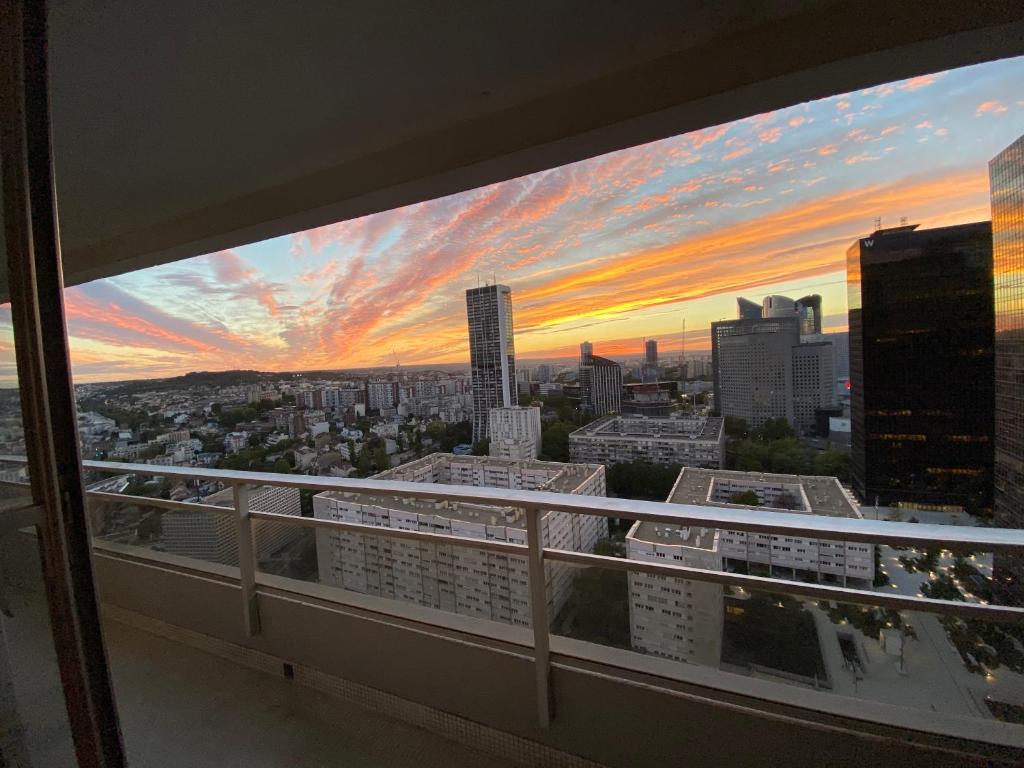 a view of a city sunset from a balcony at Appartement La Défense The View in Puteaux