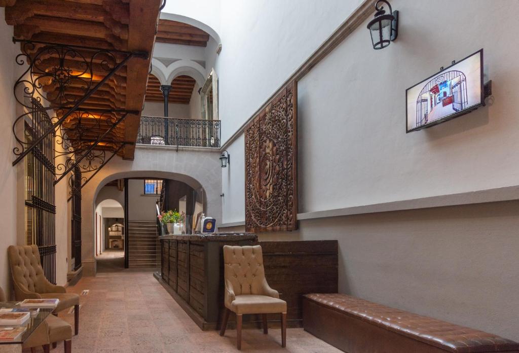 a hallway with chairs and a bar in a building at Hotel Madero in Querétaro