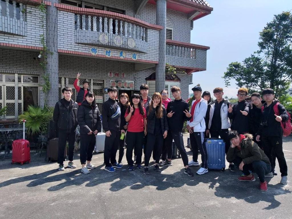 a group of people posing for a picture in front of a building at Yilan Xiang Feng Homestay in Wujie