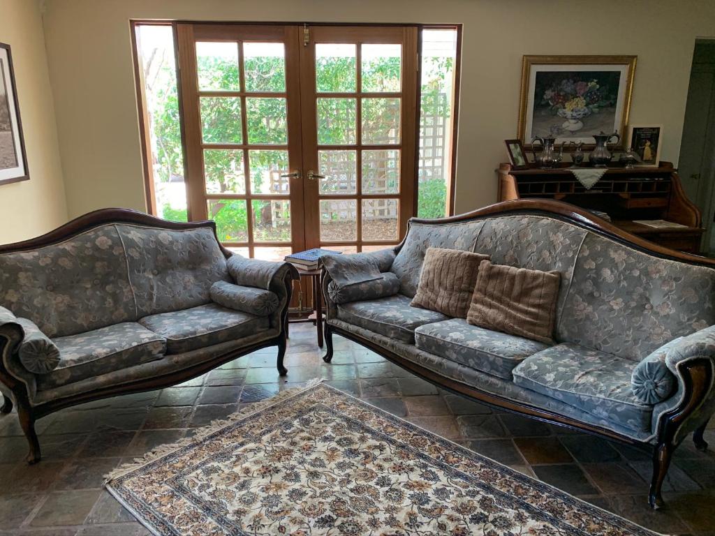 a living room with two couches and a rug at Weelaway On Gregory in Geraldton