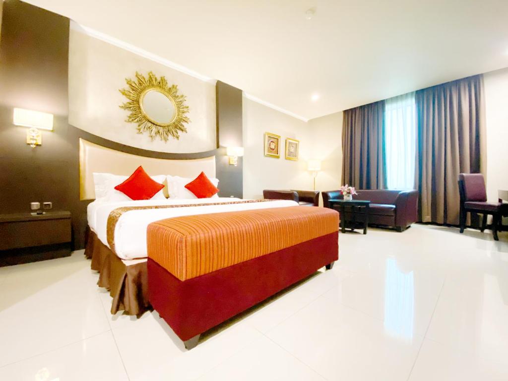 a hotel room with a bed and a living room at Grand Paragon Hotel in Jakarta