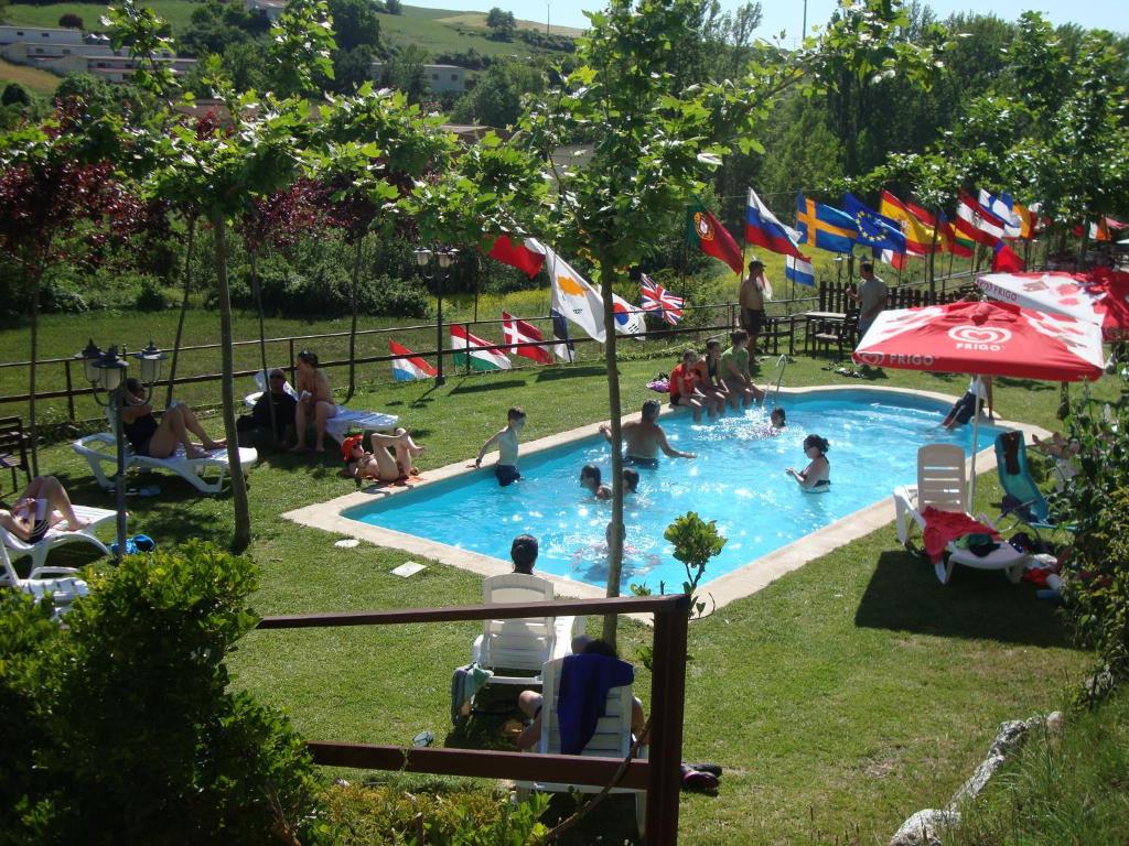 grupa ludzi siedzących wokół basenu w obiekcie Albergue de Peregrinos A Santiago w mieście Belorado