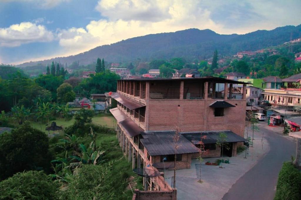 un gran edificio de ladrillo en una ciudad con una montaña en Vila NJD en Bogor