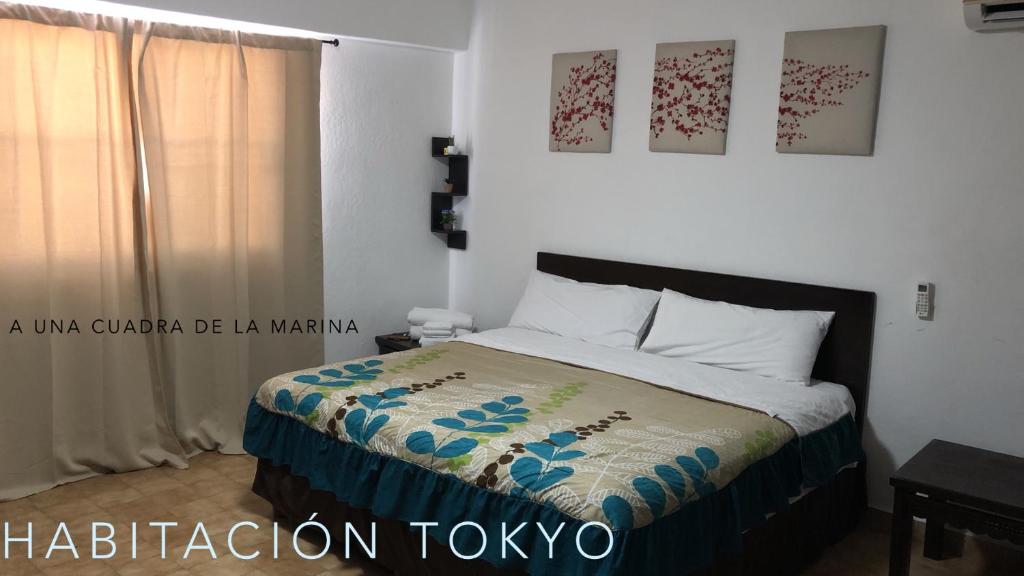 um quarto com uma cama com uma colcha em Cabo Tortuga Hotel Boutique em Cabo San Lucas