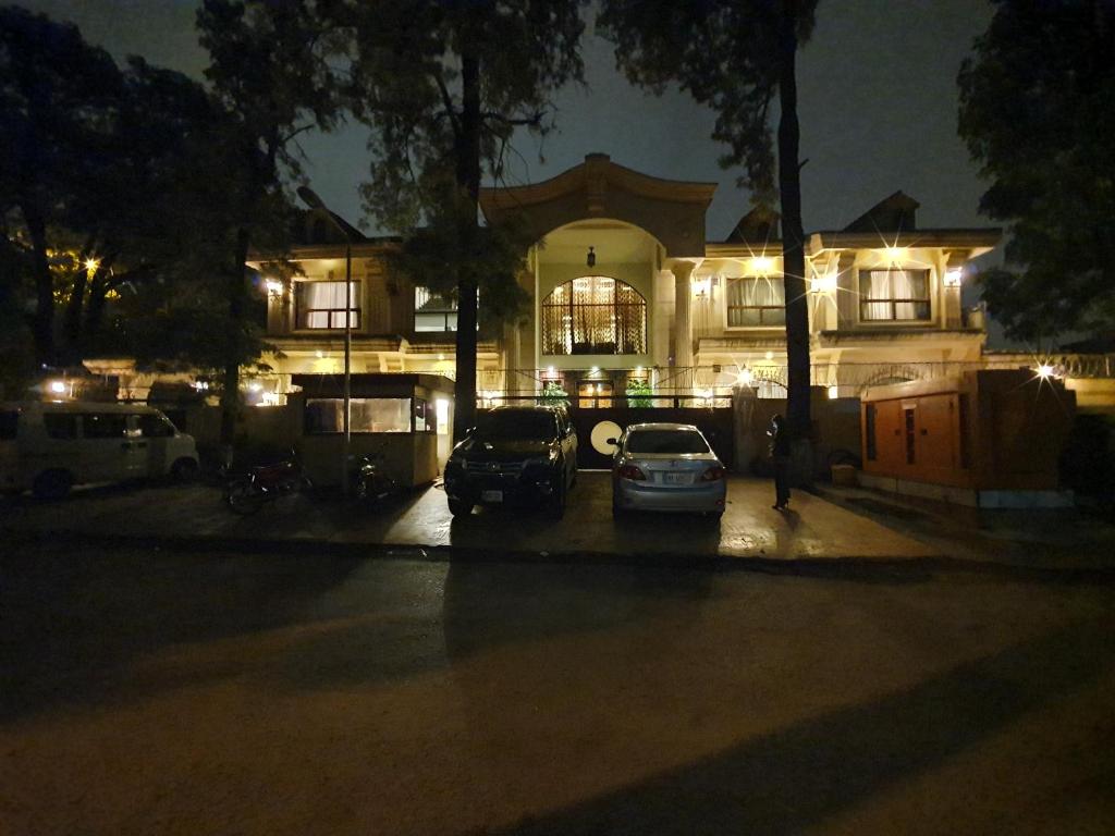 two cars parked in front of a building at night at S Chalet Islamabad in Islamabad