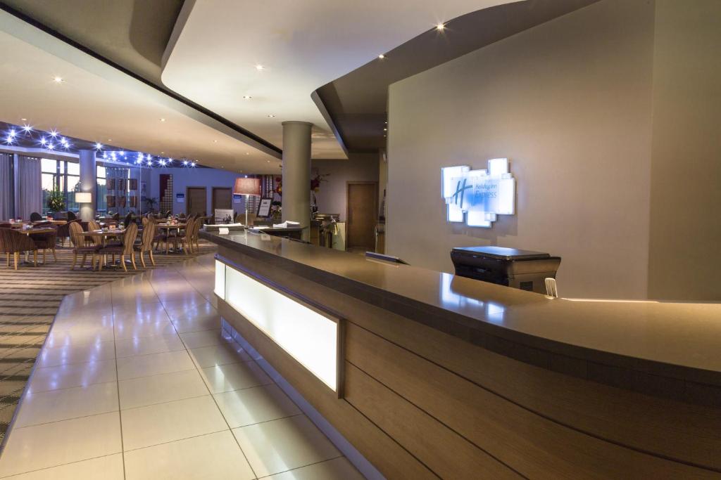Johannesburg的住宿－桑頓伍德米德智選假日酒店，餐厅内的酒吧配有桌椅