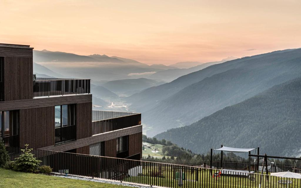 a building with a view of the mountains at Aparthotel Panorama Living Dolomites in Maranza