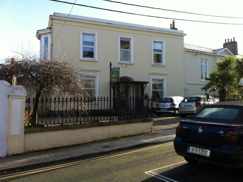 una casa en una calle con autos estacionados frente a ella en Windsor Lodge B&B en Dun Laoghaire