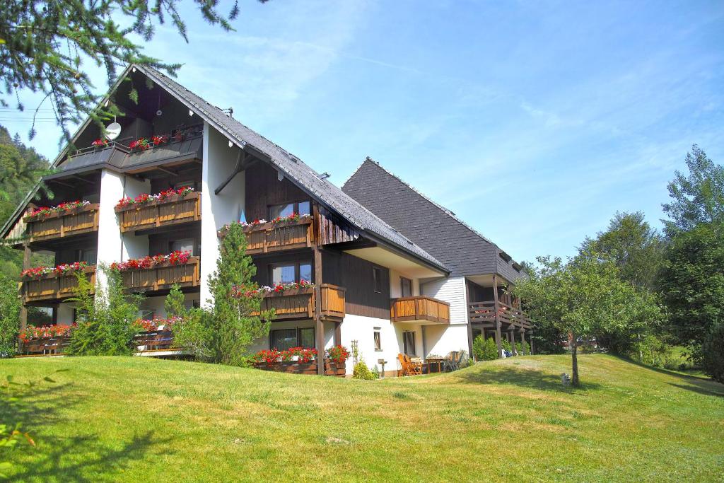 un gran edificio con macetas en los balcones en B1 Albmatte-FEWO Sauna, Hallenbad Außenbecken Massagen nebenan, en Menzenschwand