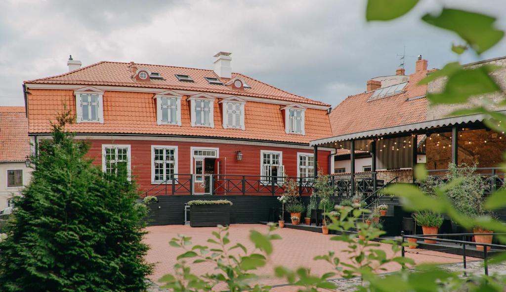a large red brick building with a black fence at Vanadziņa māja in Cēsis