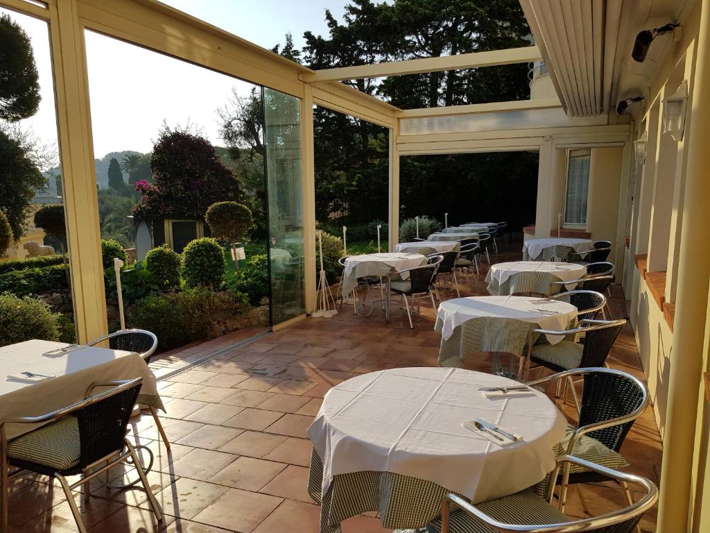 a room with tables and chairs on a patio at Hôtel de Charme Brise Marine in Saint-Jean-Cap-Ferrat