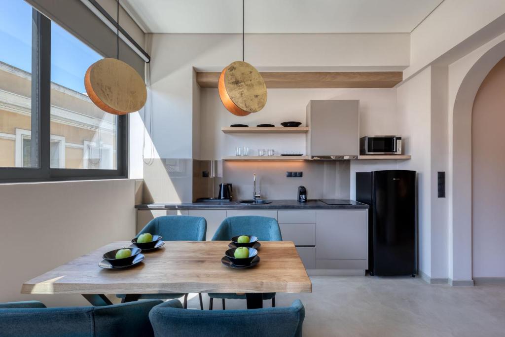 a kitchen and dining room with a wooden table and chairs at Muse Urban Suites in Athens