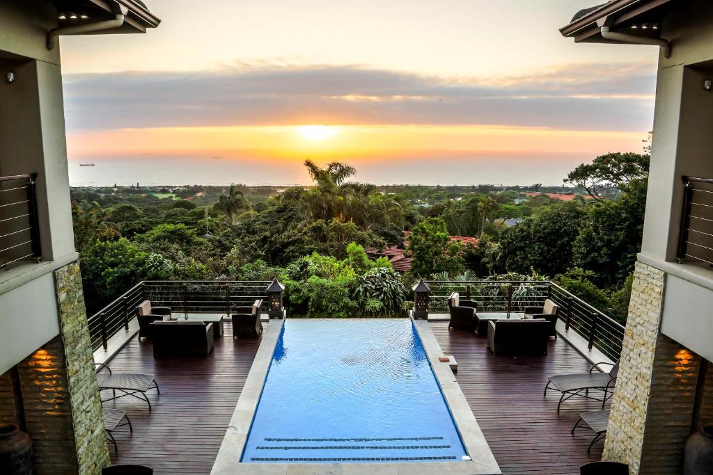 Blick auf den Pool von einem Gebäude mit Sonnenuntergang in der Unterkunft Endless Horizons Boutique Hotel in Durban