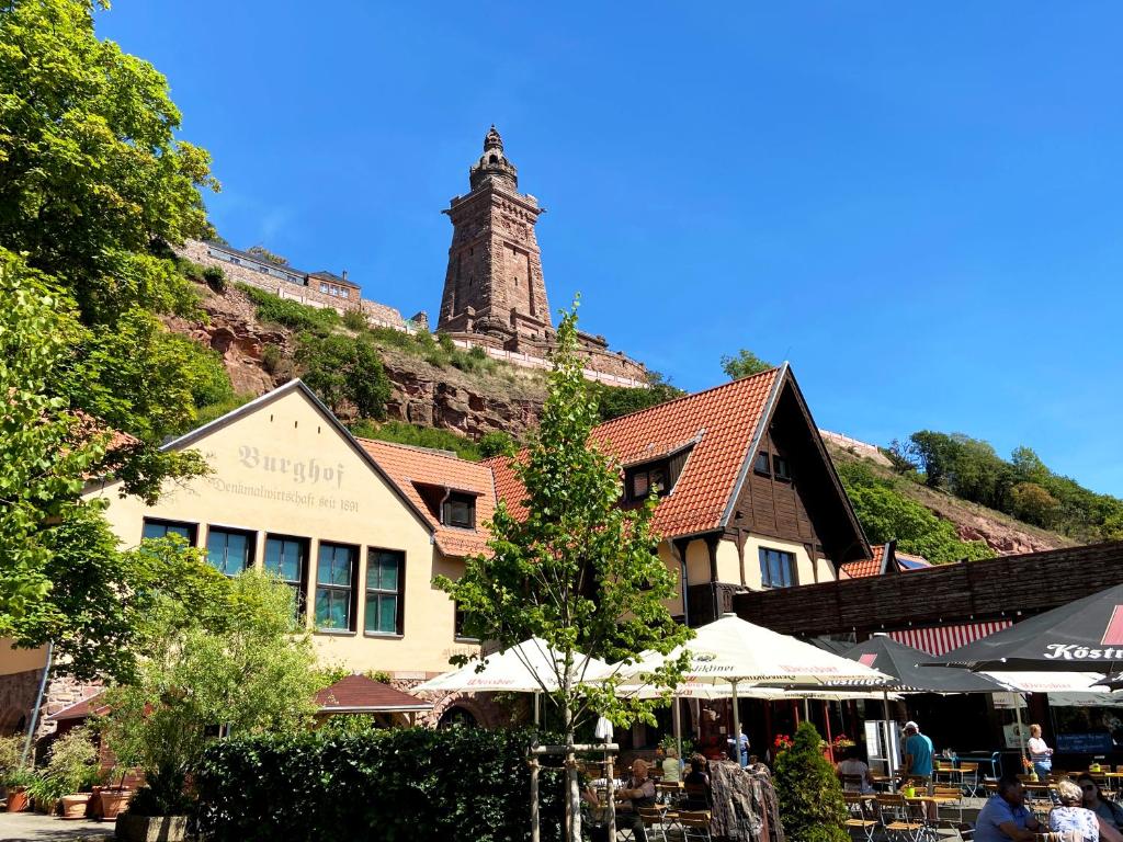 un edificio con una torre de reloj en la cima de una colina en Burghof Kyffhäuser en Bad Frankenhausen