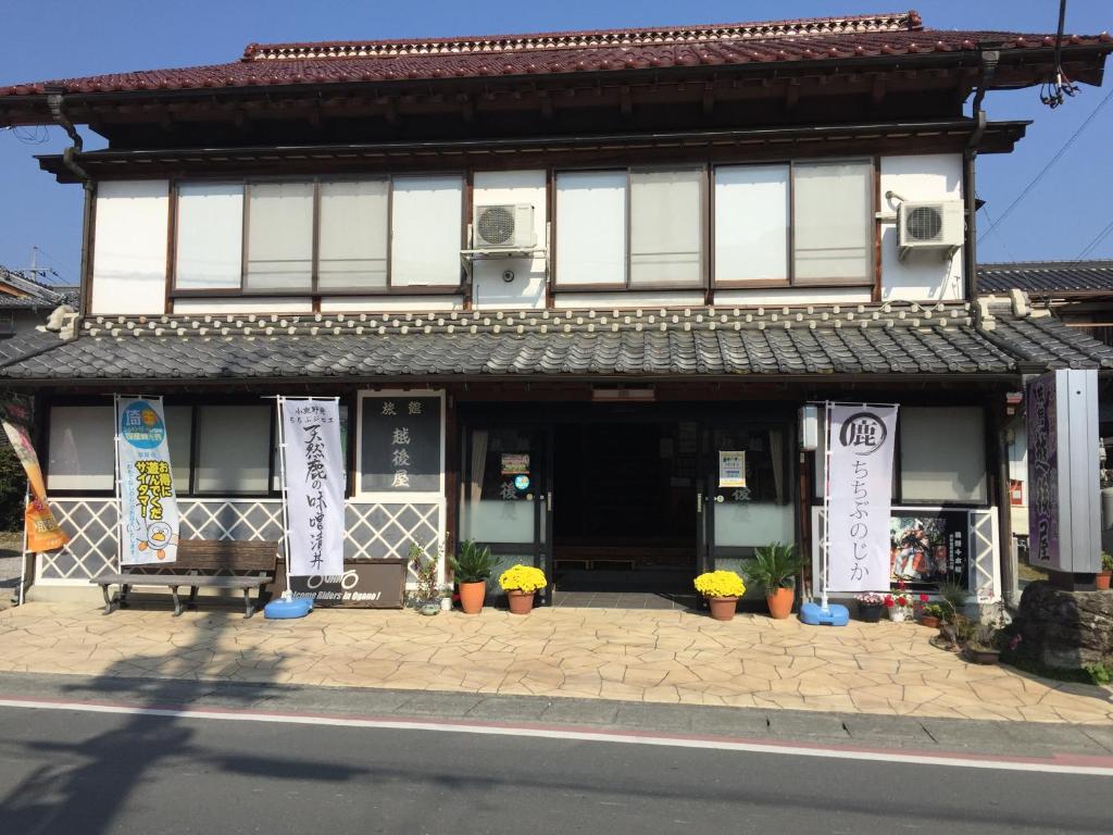a building on the side of a street with flowers in front at Echigoya Ryokan in Ogano