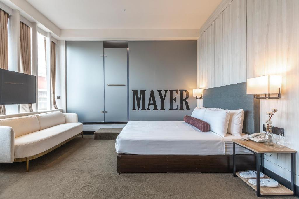 een hotelkamer met een groot bed en een bank bij Mayer Inn in Taipei