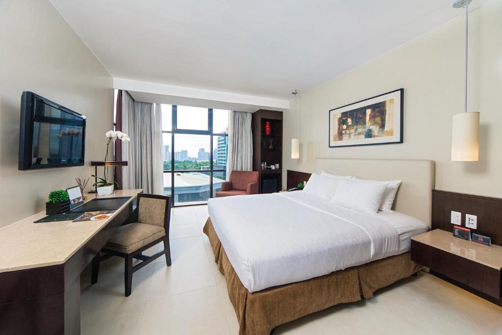 una camera d'albergo con letto e scrivania con computer di The B Hotel Alabang a Manila