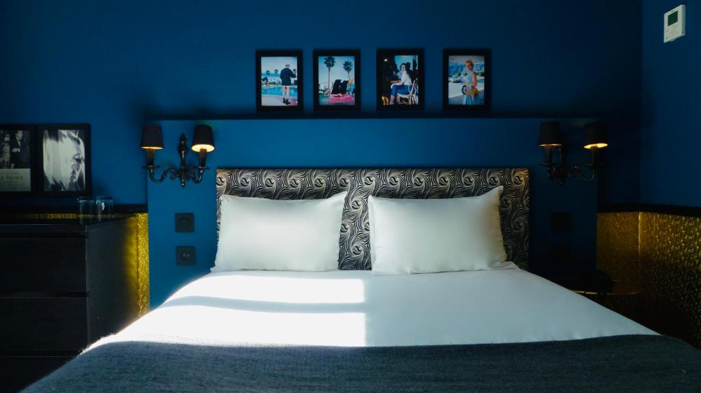 パリにあるオテル ノワールの青いベッドルーム(白いシーツを使用した大型ベッド1台付)