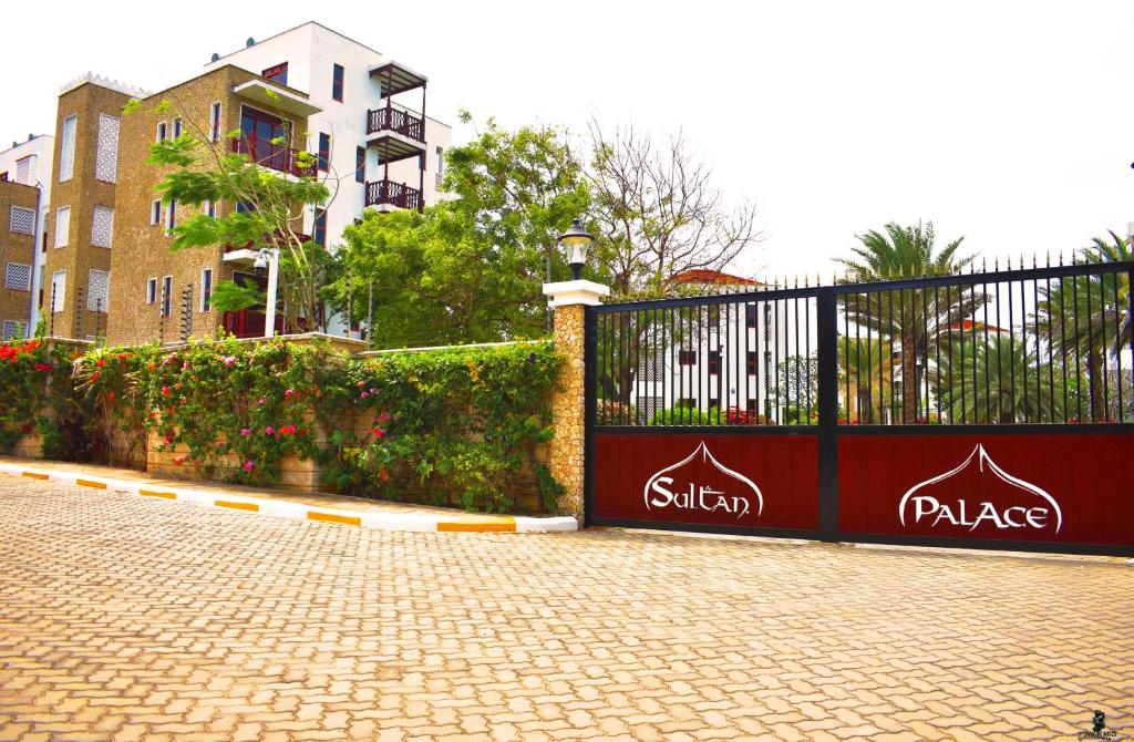 ein Tor auf einer Backsteinstraße neben einem Gebäude in der Unterkunft Sultan Palace Beach Resort - AMANI Apartment CB2-202 in Kikambala