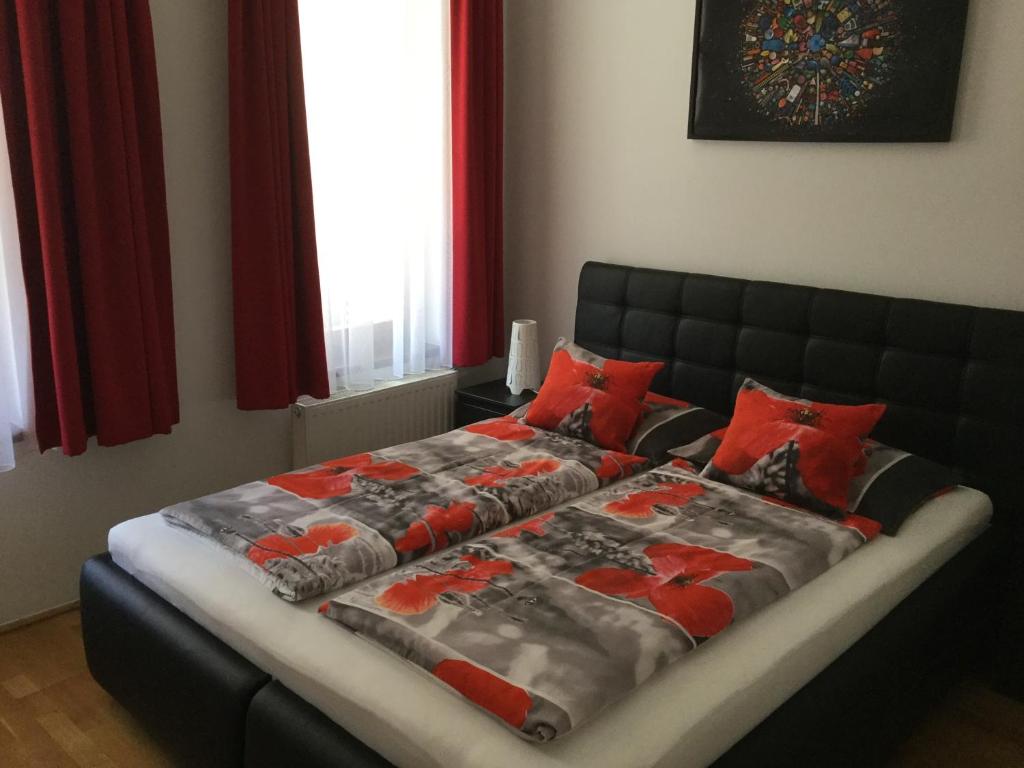 ブダペストにあるLia's Apartment in Gozsdu and Free Parkingの赤い枕が付いたベッドルームのベッド1台