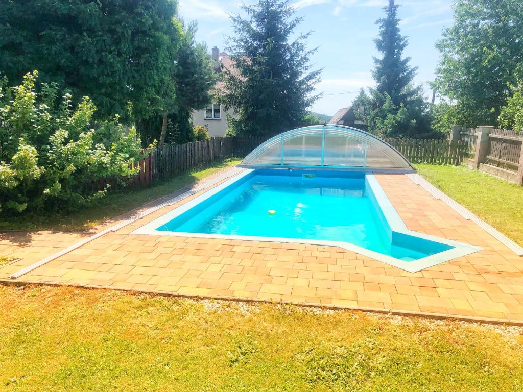 a swimming pool with a glass dome in a yard at Apartmány Slunečnice in Konstantinovy Lázně