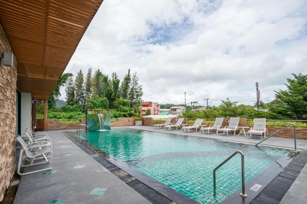 a swimming pool with lounge chairs in a building at CA Hotel and Residence Phuket - SHA Extra Plus in Phuket