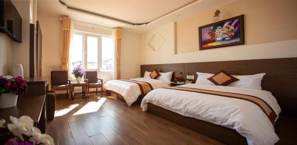 a hotel room with two beds and a window at New Hampton Suits-Tam Xuan Centre Hotel in Da Lat