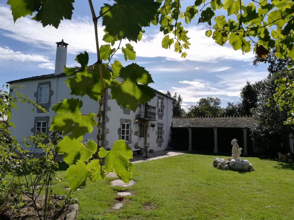 a large white building with a grass yard at Casa Oute in Sobrada