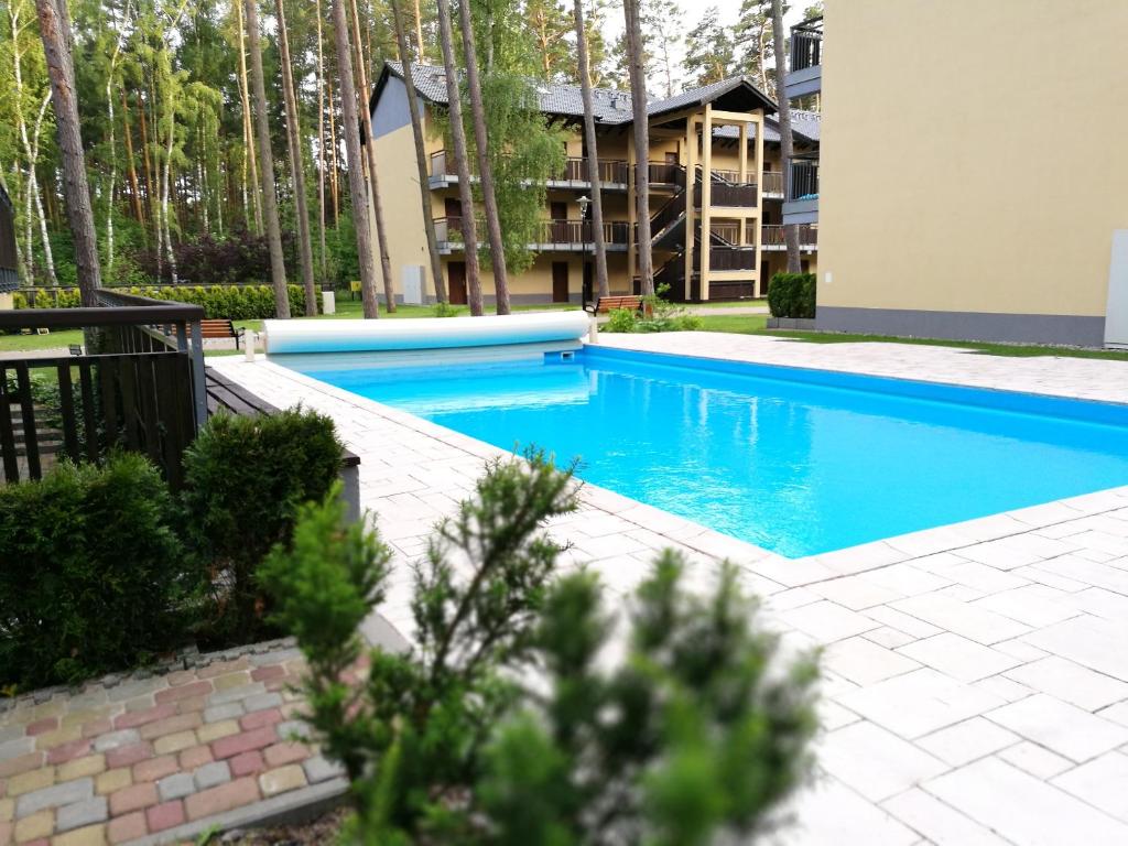 a swimming pool in front of a building at Sea&Forest Pogorzelica Apartament Platynowy in Pogorzelica
