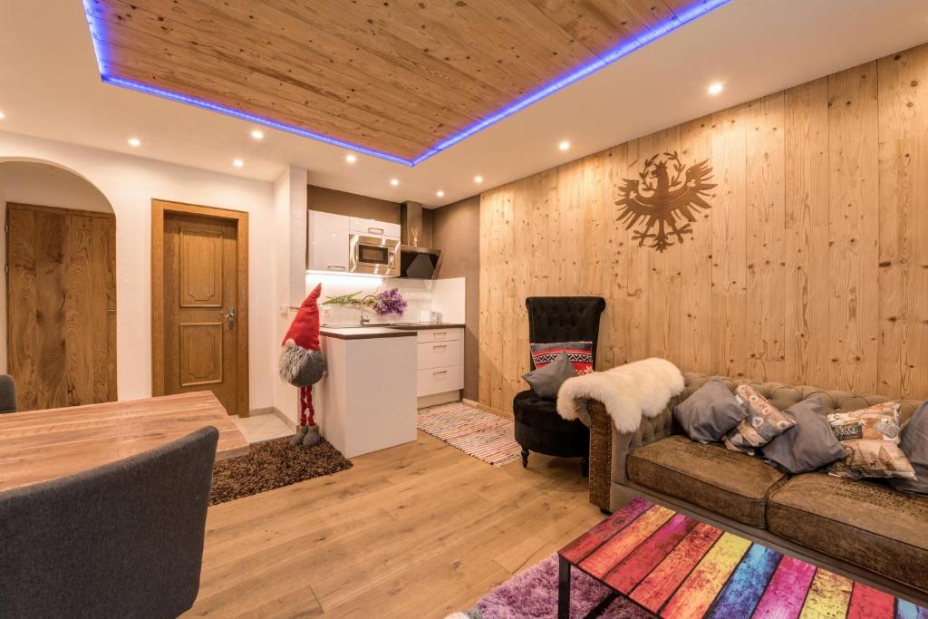 a living room with a couch and a kitchen at Quality Hosts Arlberg - ALPtyrol Appartements in Sankt Anton am Arlberg