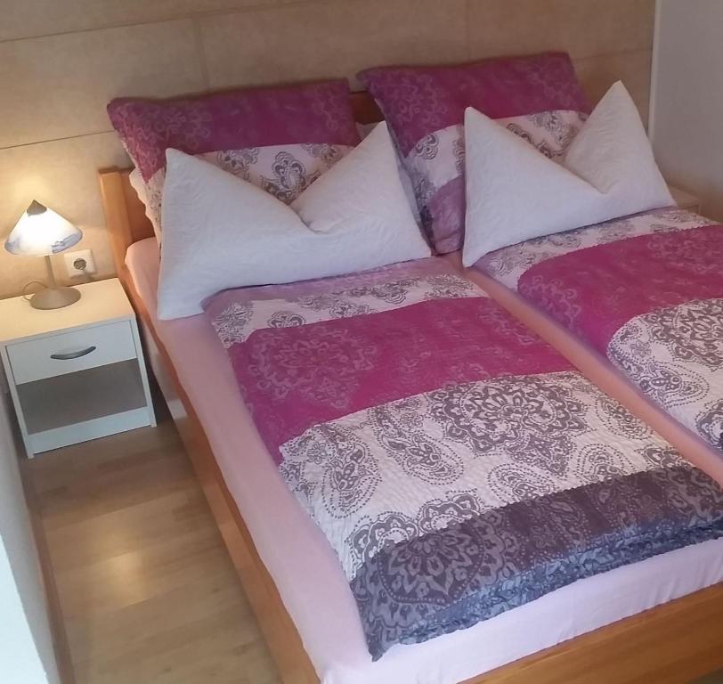a bedroom with two beds with purple and white pillows at Ferienwohnung Beitz in Lahr