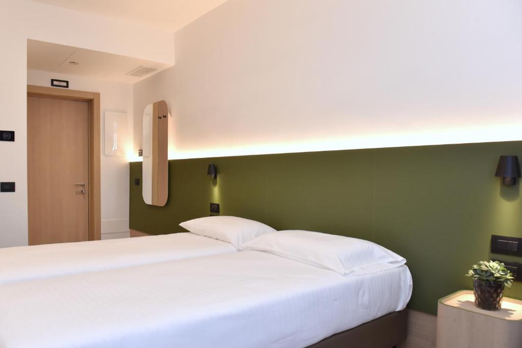 a bedroom with a white bed and white walls at Hotel Casa Del Pellegrino in Padova