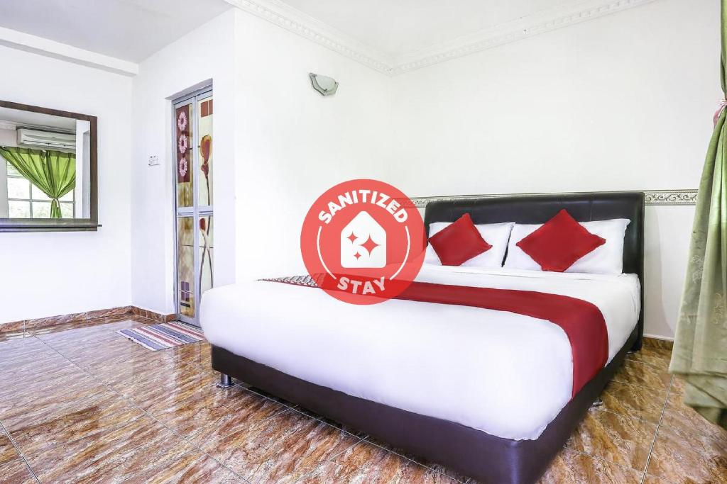 a bedroom with a bed with a sign on it at D' Anjung Inn in Tangkak