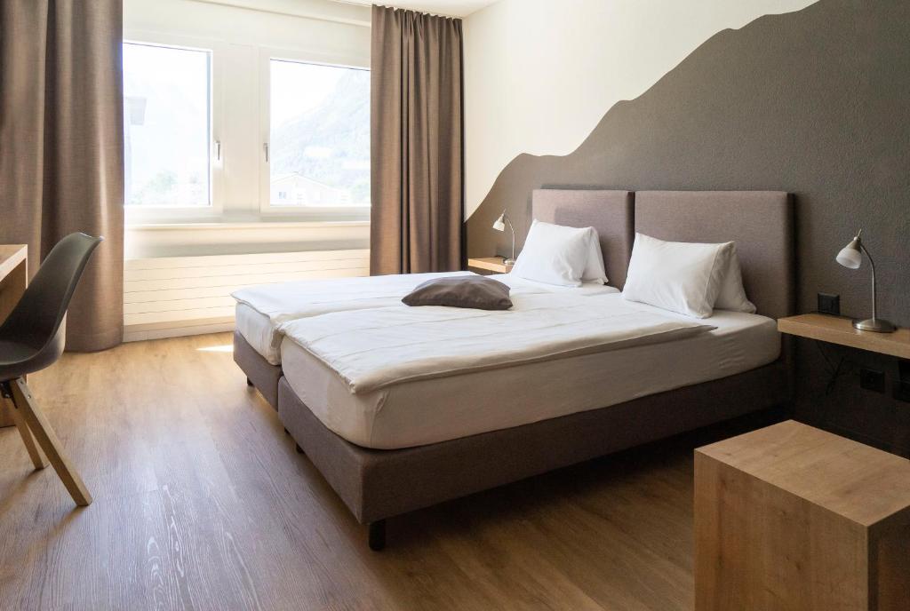 Postel nebo postele na pokoji v ubytování Tailormade Hotel STANS SÜD