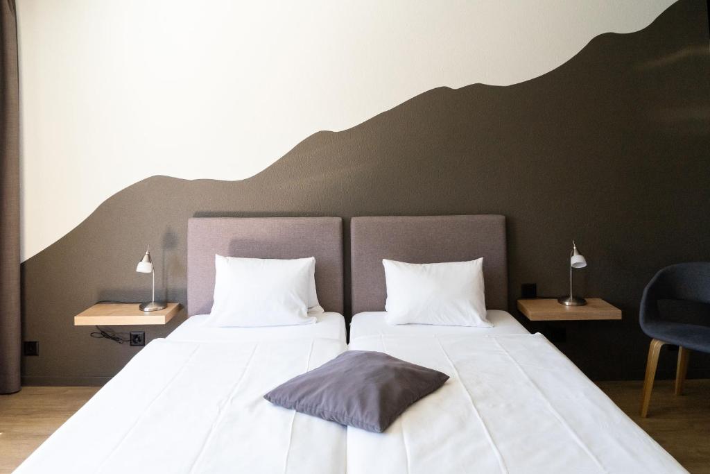 Postel nebo postele na pokoji v ubytování Tailormade Hotel STANS SÜD