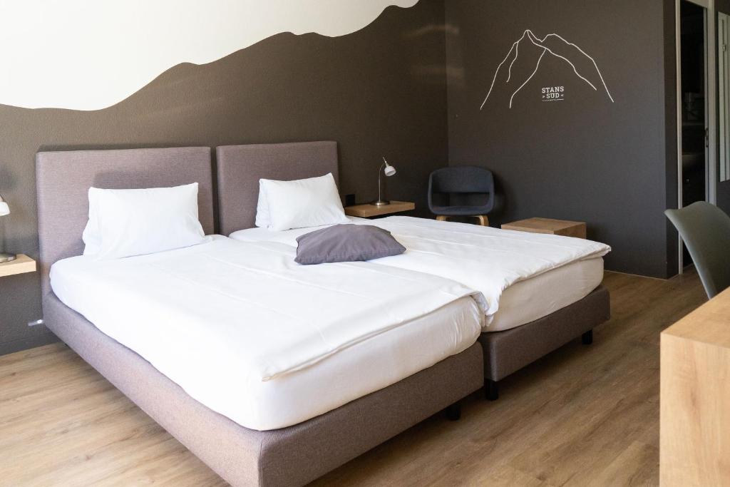 Postel nebo postele na pokoji v ubytování Tailormade Hotel STANS SÜD