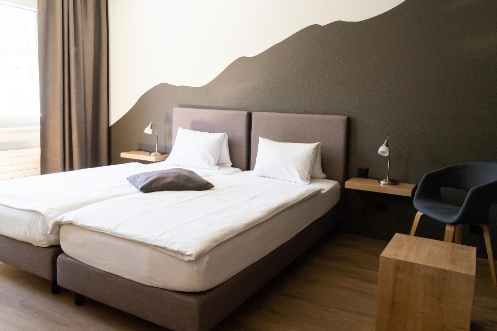Postel nebo postele na pokoji v ubytování Tailormade Hotel STANS SÜD