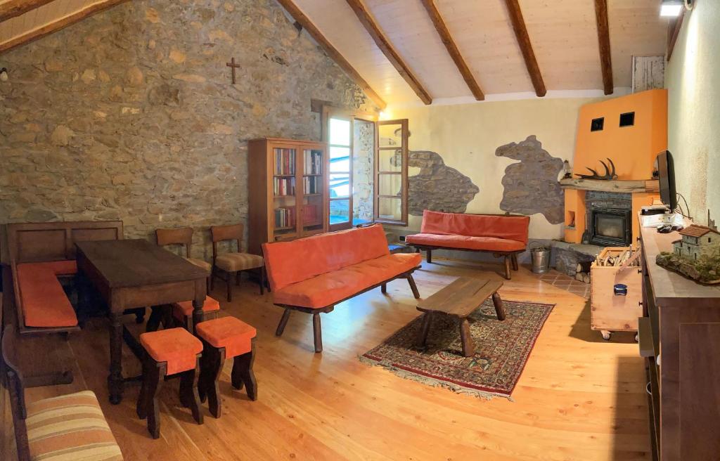 una sala de estar con mesas y sillas y una pared de piedra. en BBB Bed&Breakfast Bagneri, en Muzzano