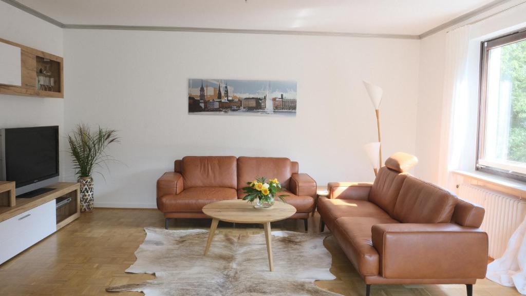 een woonkamer met 2 stoelen en een tafel bij Summerset Ferienwohnung in Rosengarten