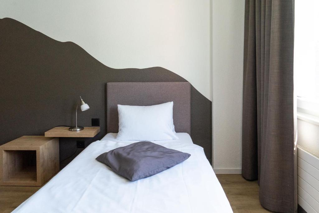 Postel nebo postele na pokoji v ubytování Tailormade Hotel STANS SÜD