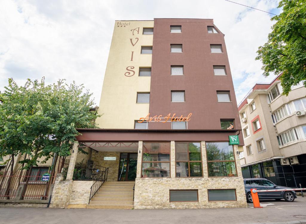 Un bâtiment avec un panneau en haut dans l'établissement Avis Hotel By WS Group, à Bucarest