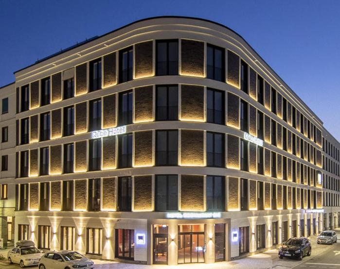 un gran edificio con coches estacionados frente a él en Qube Hotel Bahnstadt, en Heidelberg