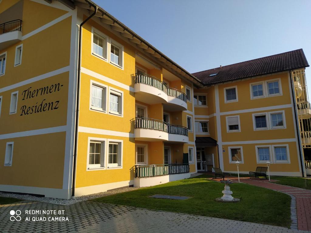 a yellow apartment building with a courtyard at Thermen-Residenz in Bad Füssing