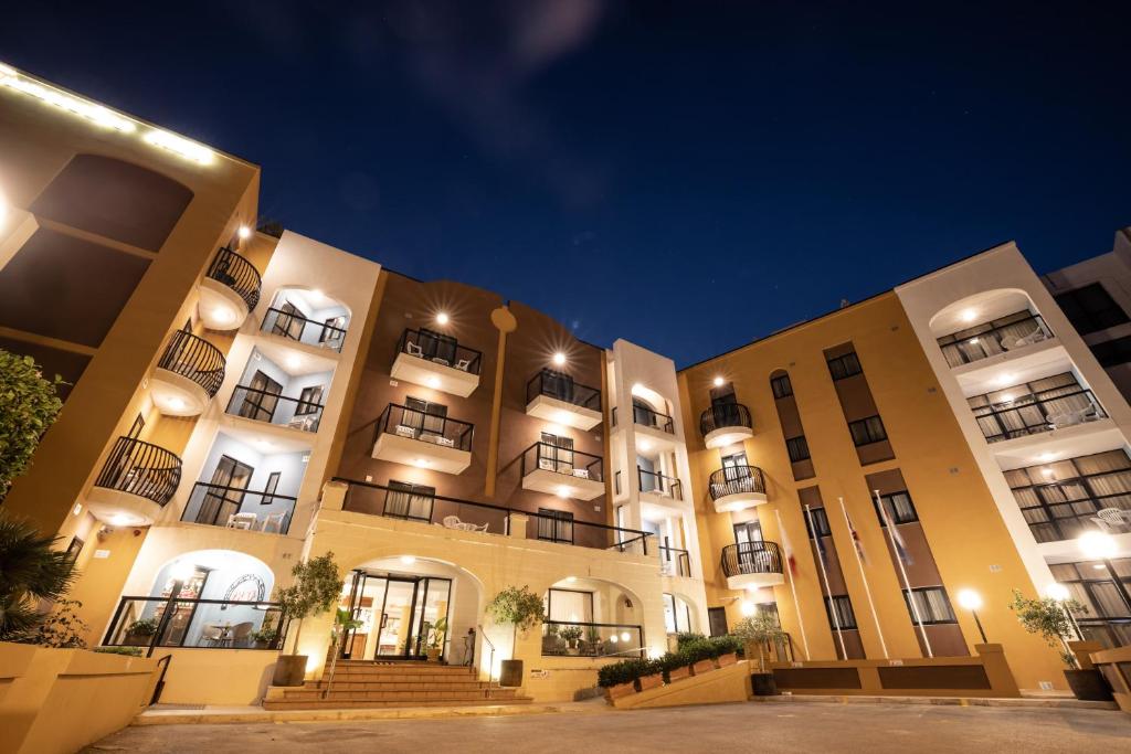 a large building with stairs in front of it at night at Sunseeker Holiday Complex in St Paul's Bay