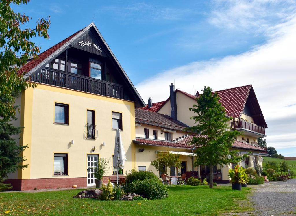 uma casa com um telhado preto em Ferienhotel Wolfsmühle em Rodishain